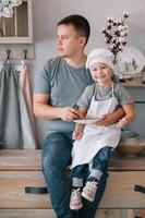 Jeune homme et le sien fils avec four feuille dans cuisine. père avec peu fils sur le cuisine photo