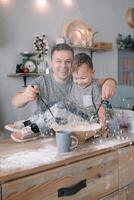 Jeune homme et le sien fils avec four feuille dans cuisine. père avec peu fils sur le cuisine. photo