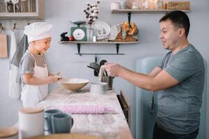 Jeune homme et le sien fils avec four feuille dans cuisine. père avec peu fils sur le cuisine. photo