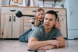 Jeune homme et le sien fils avec four feuille dans cuisine. père avec peu fils sur le cuisine photo