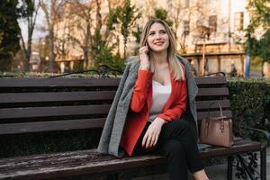 Jeune à la mode affaires femme dans se dépêcher sur ville rue, parlant sur mobile téléphone. photo