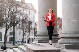 portrait de affaires femmes dans sentiment de concentrer stress et voir supporter et tenir le papier fichier feuille dans le Extérieur piéton marcher façon avec le ville espace de extérieur moderne façade bâtiment. photo