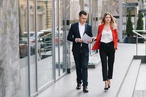 affaires gens en marchant et parlant dans le rue oreille de moderne bâtiment. photo