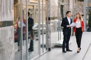 affaires gens en marchant et parlant dans le rue oreille de moderne bâtiment. photo