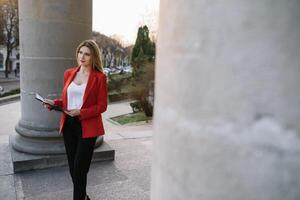 portrait de affaires femmes dans sentiment de concentrer stress et voir supporter et tenir le papier fichier feuille dans le Extérieur piéton marcher façon avec le ville espace de extérieur moderne façade bâtiment. photo