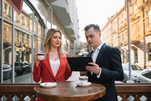 Beau et sur de soi homme d'affaire en utilisant portable ordinateur et La technologie gadget téléphone intelligent Extérieur discuter avec magnifique affaires partenaire .nouveau moderne affaires gens mode de vie photo