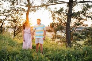 profiter temps ensemble. élégant et aimant couple profiter chaque autre par le mer. le couple est Jeune et dans l'amour. le concept de jeunesse, l'amour et mode de vie. magnifique le coucher du soleil sur une été journée photo