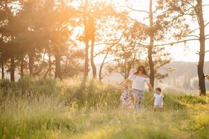 élégant mère et Beau fille ayant amusement sur le la nature. content famille concept. beauté la nature scène avec famille Extérieur mode de vie. famille repos ensemble. bonheur dans famille vie. les mères journée. photo