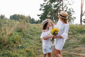 élégant mère et Beau fille ayant amusement sur le la nature. content famille concept. beauté la nature scène avec famille Extérieur mode de vie. famille repos ensemble. bonheur dans famille vie. les mères journée. photo