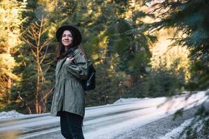 content fille avec chapeau dans forêt à Montagne route arrière-plan, se détendre temps sur vacances concept Voyage ,couleur de ancien Ton et doux concentrer photo