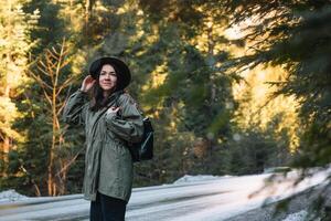 content fille avec chapeau dans forêt à Montagne route arrière-plan, se détendre temps sur vacances concept Voyage ,couleur de ancien Ton et doux se concentrer. photo