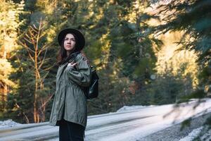 content fille avec chapeau dans forêt à Montagne route arrière-plan, se détendre temps sur vacances concept Voyage ,couleur de ancien Ton et doux se concentrer. photo