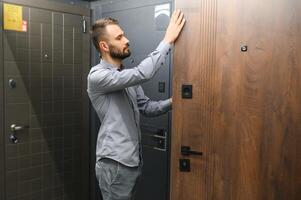 acheteur choisit porte dans magasin. magasin fenêtre de des portes. une grand sélection de des portes pour maison photo