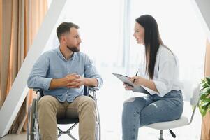 Jeune barbu homme sur fauteuil roulant pendant Accueil psychothérapie photo