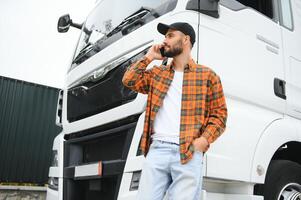 homme camionneur parlant sur le téléphone par le sien blanc un camion photo