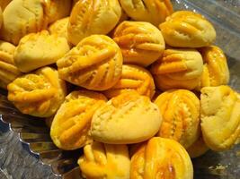 proche en haut de Nastar biscuits ou ananas Tarte doublé en haut soigneusement sur noir petit gâteau papier. photo