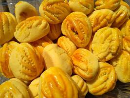 proche en haut de Nastar biscuits ou ananas Tarte doublé en haut soigneusement sur noir petit gâteau papier. photo