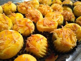 proche en haut de Nastar biscuits ou ananas Tarte doublé en haut soigneusement sur noir petit gâteau papier. photo