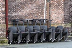 grand quantités de empilés chaises dans de face de brique mur photo