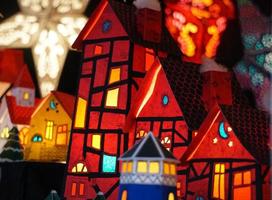 maisons de papier rouge, phare bleu et étoile blanche comme lanternes de noël sur le marché de noël photo