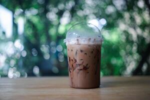 Plastique tasse de glacé cacao sur bois table photo