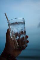 une homme en portant une verre de l'eau photo