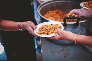 bénévoles distribuer Facile repas à le pauvres à le gratuit nourriture cuisine. photo