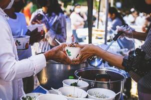 bénévoles portion chaud repas à faim les migrants humanitaire aide concept. photo