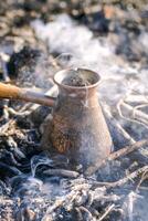 fabrication café dans cezve sur le feu lorsque camping ou randonnée dans le la nature. café sur feu de camp. photo