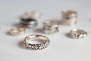 artisanat élégant argent anneaux. élégant bijoux sur une doux blanc Contexte. photo