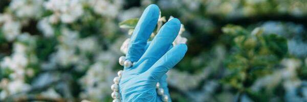 aux femmes mains dans médical gants et une perle bracelet. mode 2020. mode pendant le pandémie. décoration pour votre mains pendant corona virus. photo