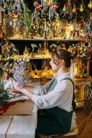 une femme dans sa fleuriste magasin recueille bouquets de fleurs. le concept de une petit entreprise. bouquets de tulipes pour le vacances sur Mars 8. photo