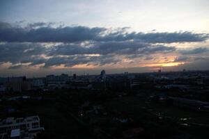 paradis nuageux ciel journée soir crépuscule temps avec lumière du soleil rayon de entre des nuages avec ville ville Contexte photo