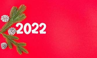 composition du nouvel an avec des branches de pin, des pommes de pin et le numéro 2022 photo