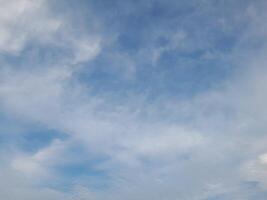 beaux nuages blancs sur fond de ciel bleu profond. de grands nuages doux et moelleux couvrent tout le ciel bleu. photo