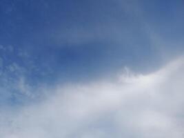 beaux nuages blancs sur fond de ciel bleu profond. de grands nuages doux et moelleux couvrent tout le ciel bleu. photo