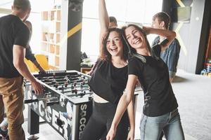 jeunes souriants jouant au baby-foot à l'intérieur photo