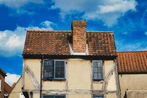 vieux européen maison avec à colombages des murs et une rouge carrelé toit contre une bleu ciel avec des nuages. ancien architecture avec visible porter et personnage dans York, Nord Yorkshire, Angleterre. photo