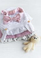 empiler de bébé vêtements, rose Bandeau et tricoté jouet lapin. photo