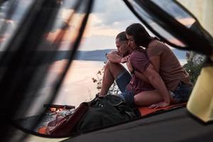 vue depuis la tente du couple allongé une vue sur le lac lors d'une randonnée. avel lifestyle concept aventure vacances en plein air photo