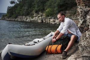 un jeune homme voyage avec un sac à dos à l'aide d'un bateau. le mode de vie du voyage et de la nature avec la nature photo