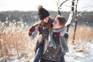 le couple s'amuse et rit. embrasser. jeune couple hipster s'embrassant dans le parc d'hiver. histoire d'amour d'hiver, un beau jeune couple élégant. concept de mode d'hiver avec petit ami et petite amie photo