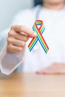 médecin avec lgbtq arc en ciel ruban pour soutien lesbienne, gay, bisexuel, transgenres et queer communauté et content fierté mois concept photo