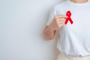 femme avec rouge ruban pour décembre monde sida jour, acquis immunitaire carence syndrome, plusieurs myélome cancer conscience mois et nationale rouge ruban semaine. soins de santé et monde cancer journée concept photo