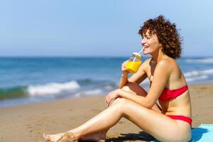 content femme profiter boisson sur plage photo