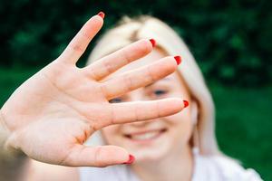 femme souriante montrant sa paume et ses doigts avec un visage heureux photo