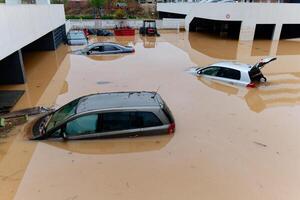 torrentiel pluie causes éclat inondations dans le ville zone. voitures en dessous de l'eau dans le condominium parking parcelle. endommagé voitures causé par lourd précipitations. bâtiments entouré par l'eau. photo