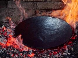 forgerons travail sur le fabrication de des pots pour traditionnel en dessous de le cloche repas, péka ou sac. vieux traditionnel artisanat. photo