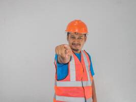 une homme portant construction montrer du doigt vers l'avant geste choisir Quelqu'un contre blanc Contexte photo