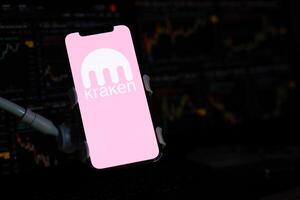 Kyiv, Ukraine - Mars 15, 2024 kraken logo sur iphone afficher écran et crypto devise valeur graphiques photo